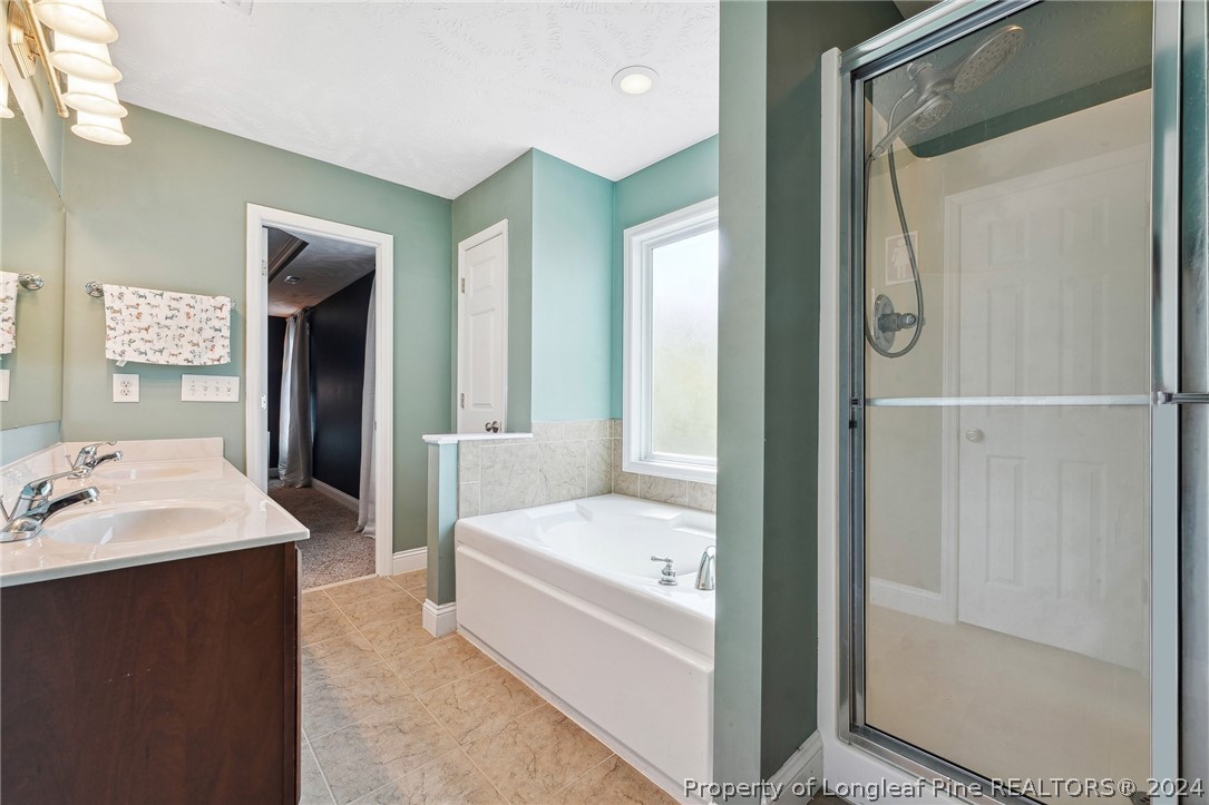 176 Vandercroft Way Bunnlevel, NC 28323 - Photo 22 of 36 a bathroom with a tub sink and mirror