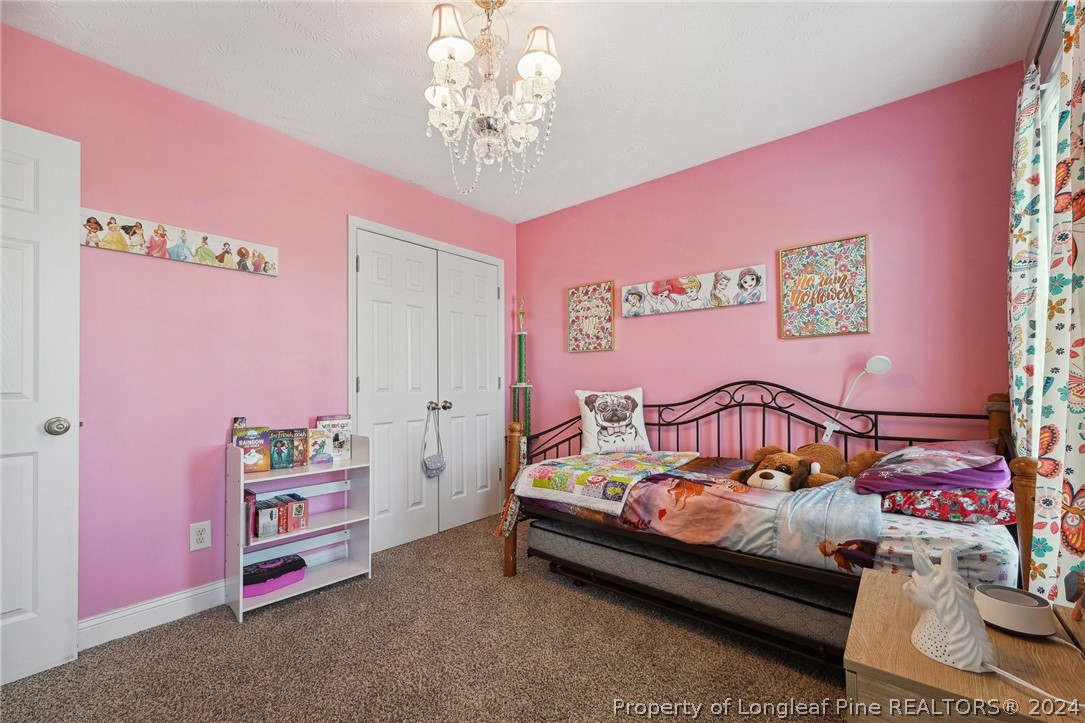 176 Vandercroft Way Bunnlevel, NC 28323 - Photo 24 of 36 a bedroom with furniture and a chandelier