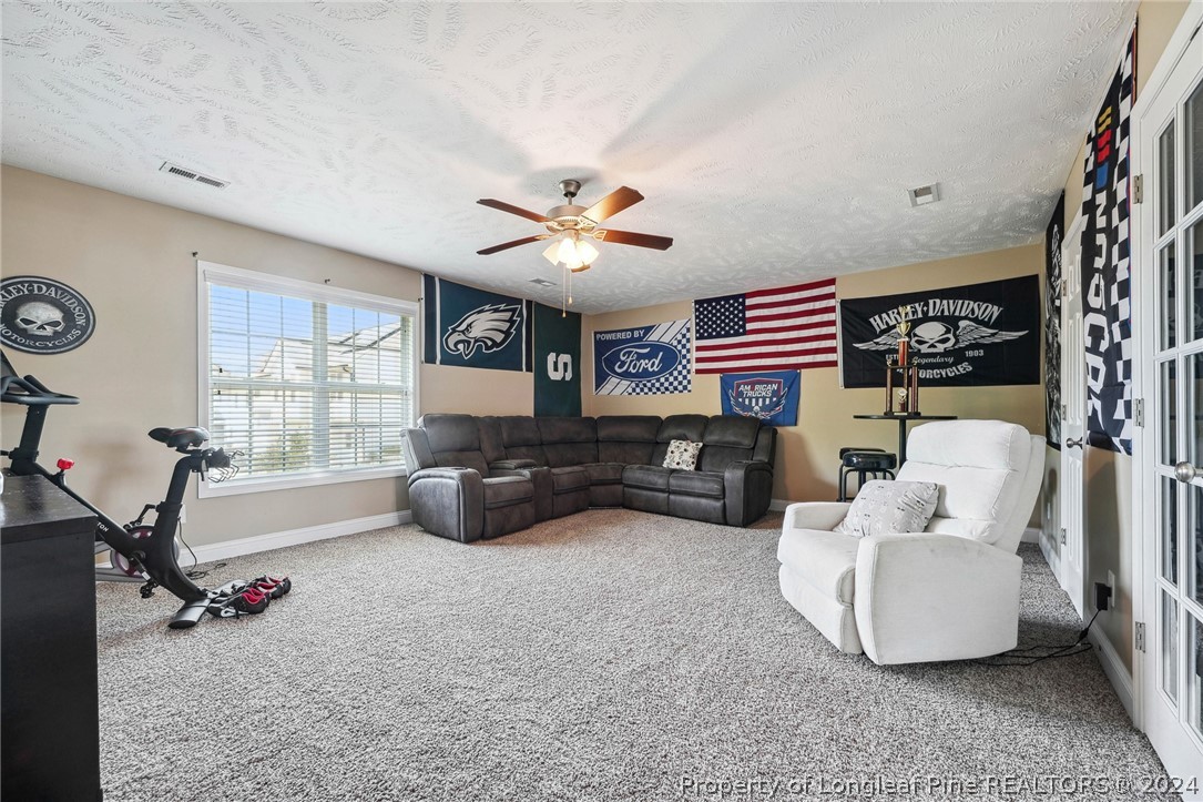 176 Vandercroft Way Bunnlevel, NC 28323 - Photo 28 of 36 a living room with furniture gym equipment and a large window