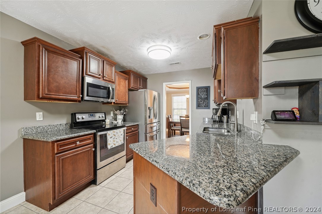 176 Vandercroft Way Bunnlevel, NC 28323 - Photo 9 of 36 a kitchen with stainless steel appliances granite countertop a sink dishwasher stove and refrigerator