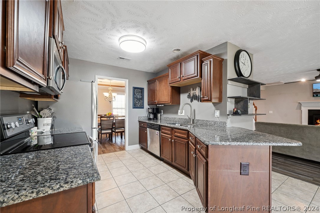 176 Vandercroft Way Bunnlevel, NC 28323 - Photo 10 of 36 a large kitchen with stainless steel appliances granite countertop a stove sink and cabinets