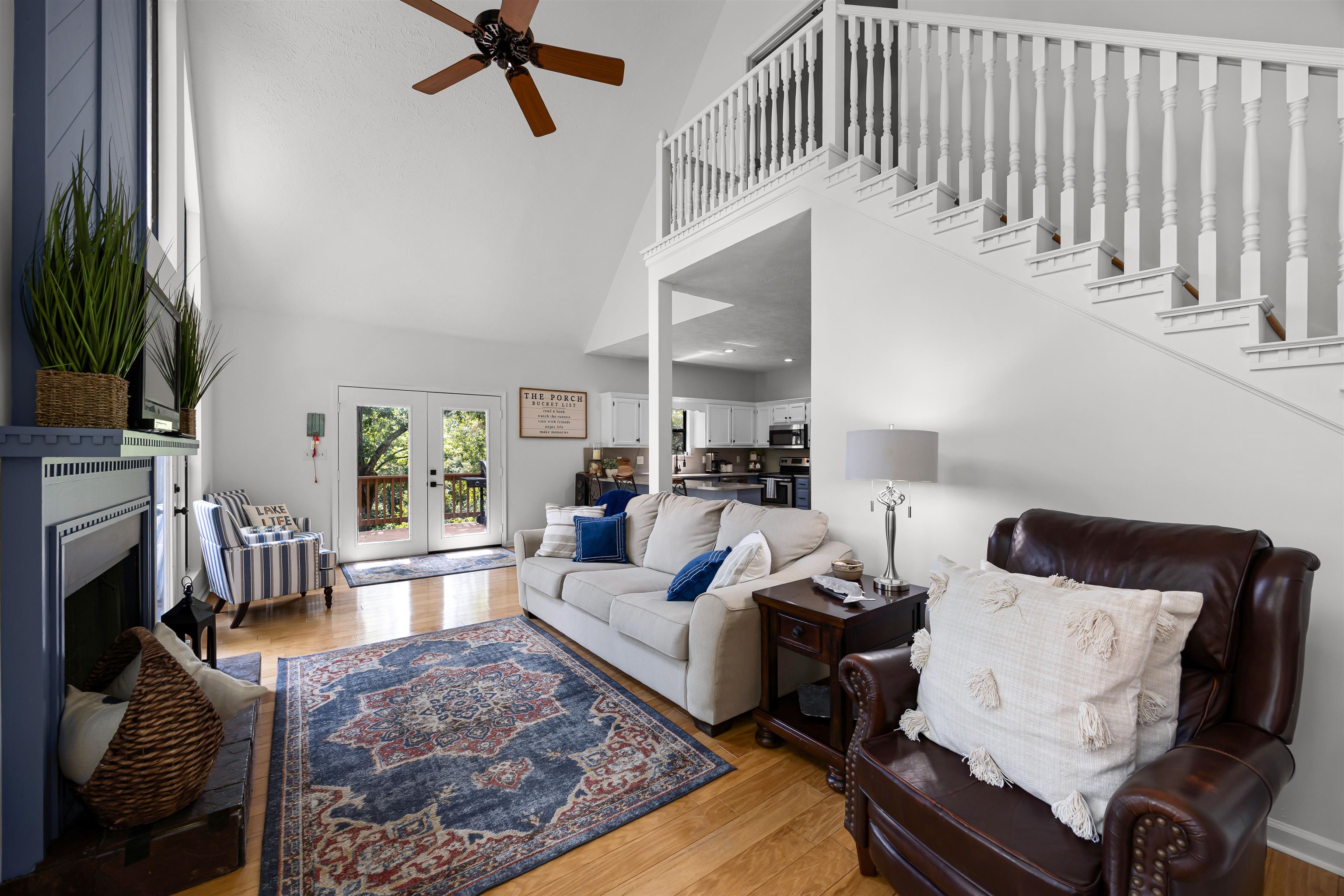 70 Point Clear Cove Savannah, TN 38372 - Photo 15 of 25 Living room featuring a high ceiling, wood finished floors, french doors, a fireplace with raised hearth, and ceiling fan
