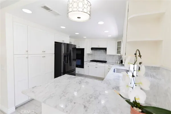 a kitchen with stainless steel appliances a refrigerator and a stove top oven