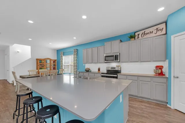 a kitchen with kitchen island a white counter top space cabinets and stainless steel appliances