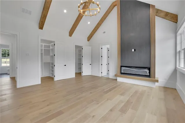 a view of an empty room with a window and a kitchen