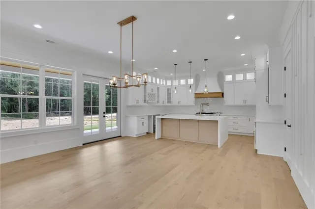 a view of a kitchen with kitchen island a sink stainless steel appliances and cabinets