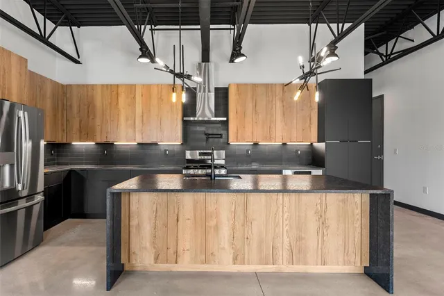 a kitchen with stainless steel appliances granite countertop a sink a stove and a refrigerator