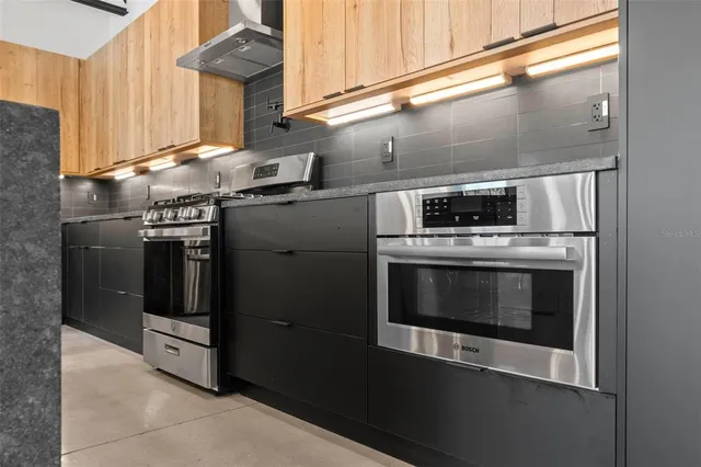 a kitchen with stainless steel appliances granite countertop a stove and a refrigerator