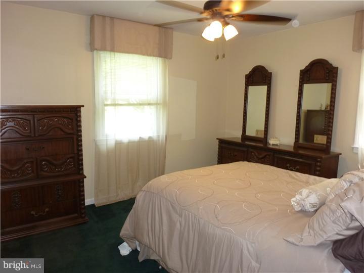 18 Warwick Road Stratford, NJ 08084 - Photo 14 of 25 a bedroom with a bed and a mirror