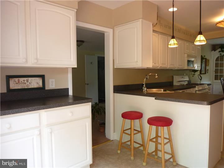 18 Warwick Road Stratford, NJ 08084 - Photo 5 of 25 a kitchen with a sink a counter and chairs