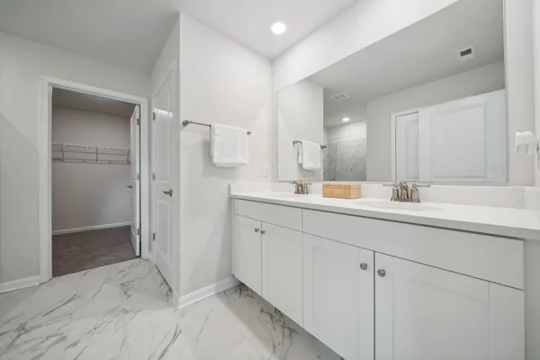a bathroom with a double vanity sink mirror and shower