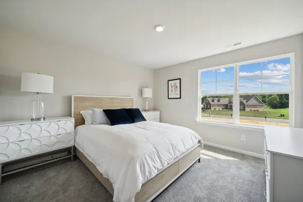 a bedroom with a large bed and a window