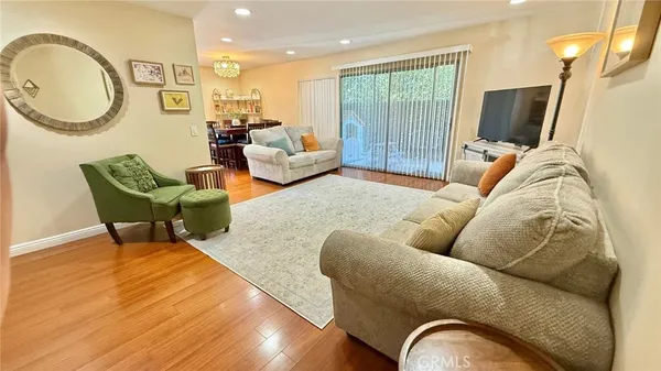 a living room with furniture a flat screen tv and a floor to ceiling window