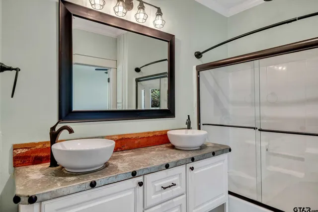 a bathroom with a granite countertop sink and a mirror