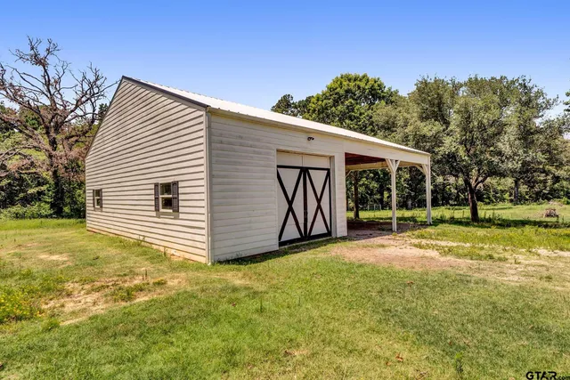 a view of a house with backyard and a tree