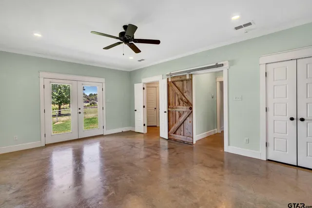 a view of empty room with wooden floor and ceiling fan