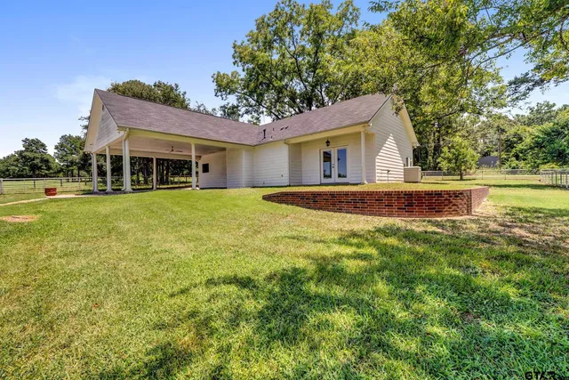 a view of a house with a yard and sitting area