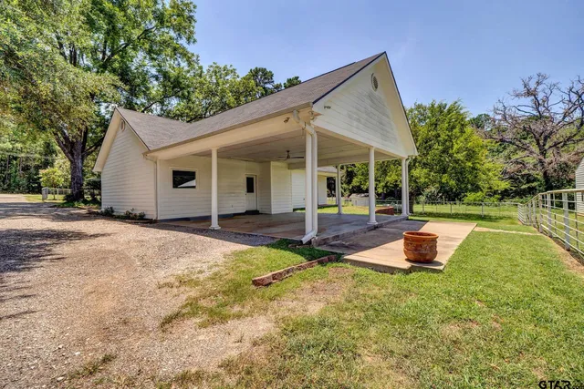 a view of a house with backyard and sitting area