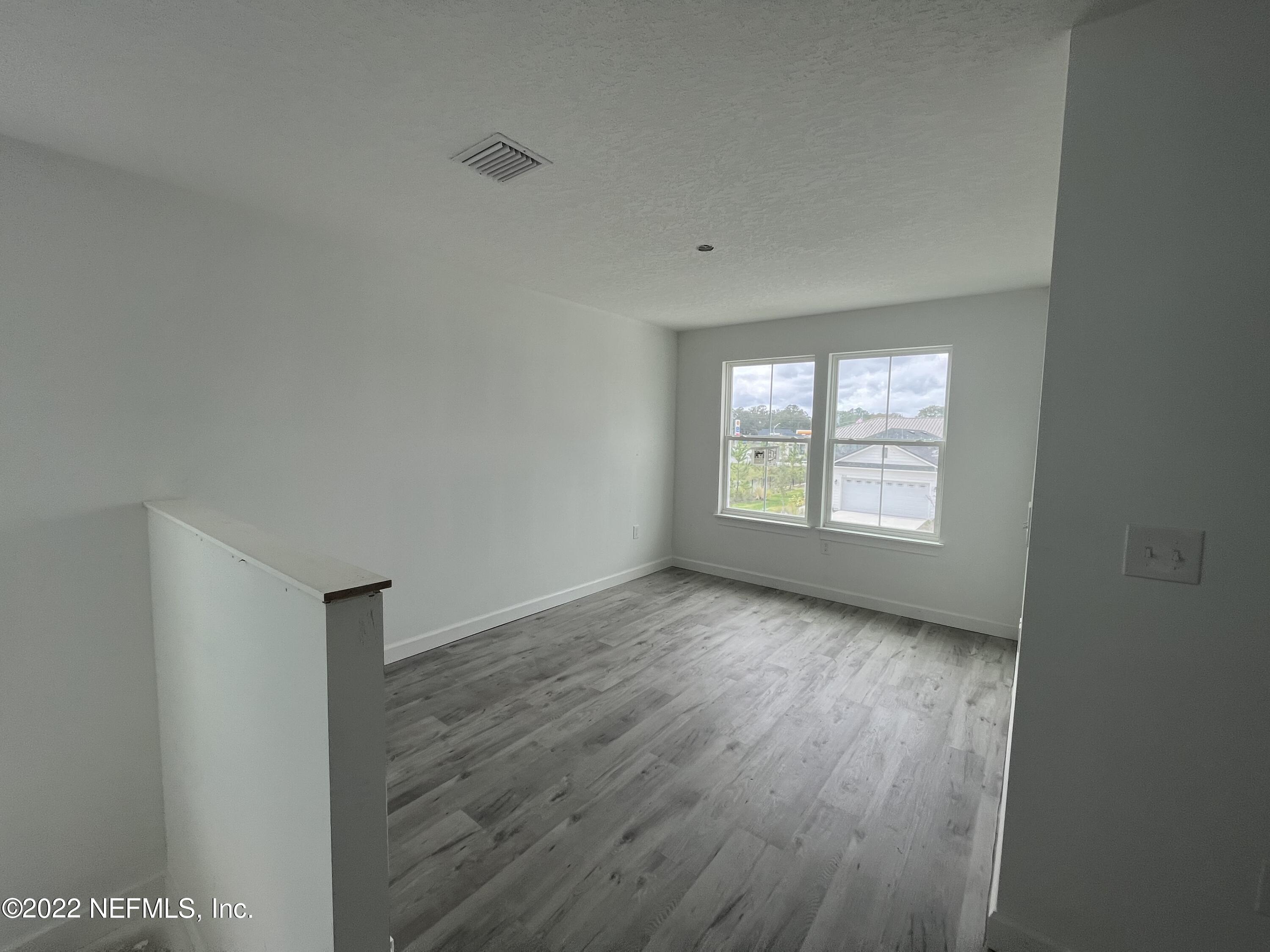 3111 Orange Picker Road Jacksonville, FL 32223 - Photo 3 of 5 an empty room with wooden floor and windows