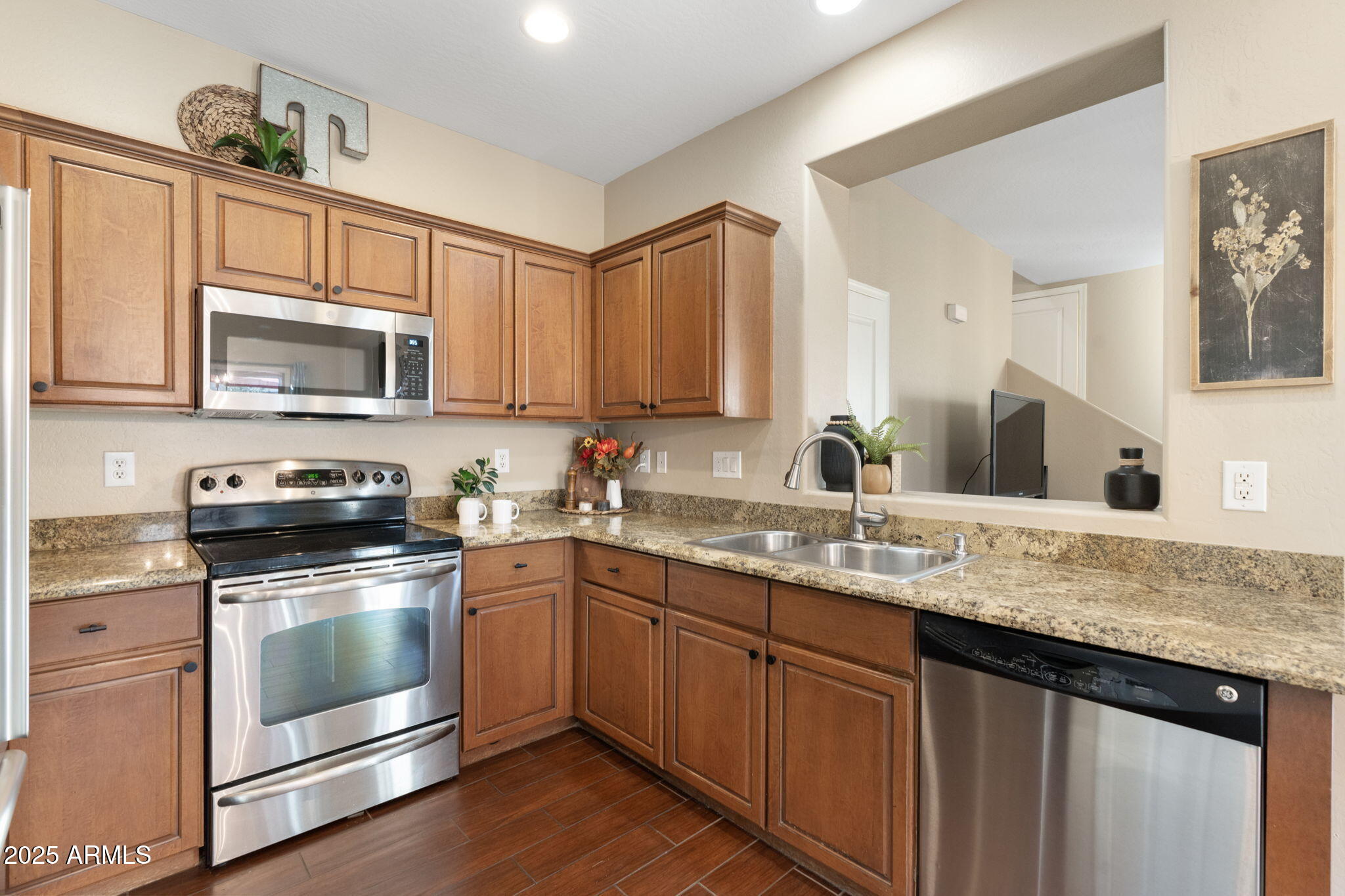 1705 East Joseph Way Gilbert, AZ 85295 - Photo 11 of 39 a kitchen with stainless steel appliances granite countertop a sink dishwasher stove and microwave with wooden cabinets