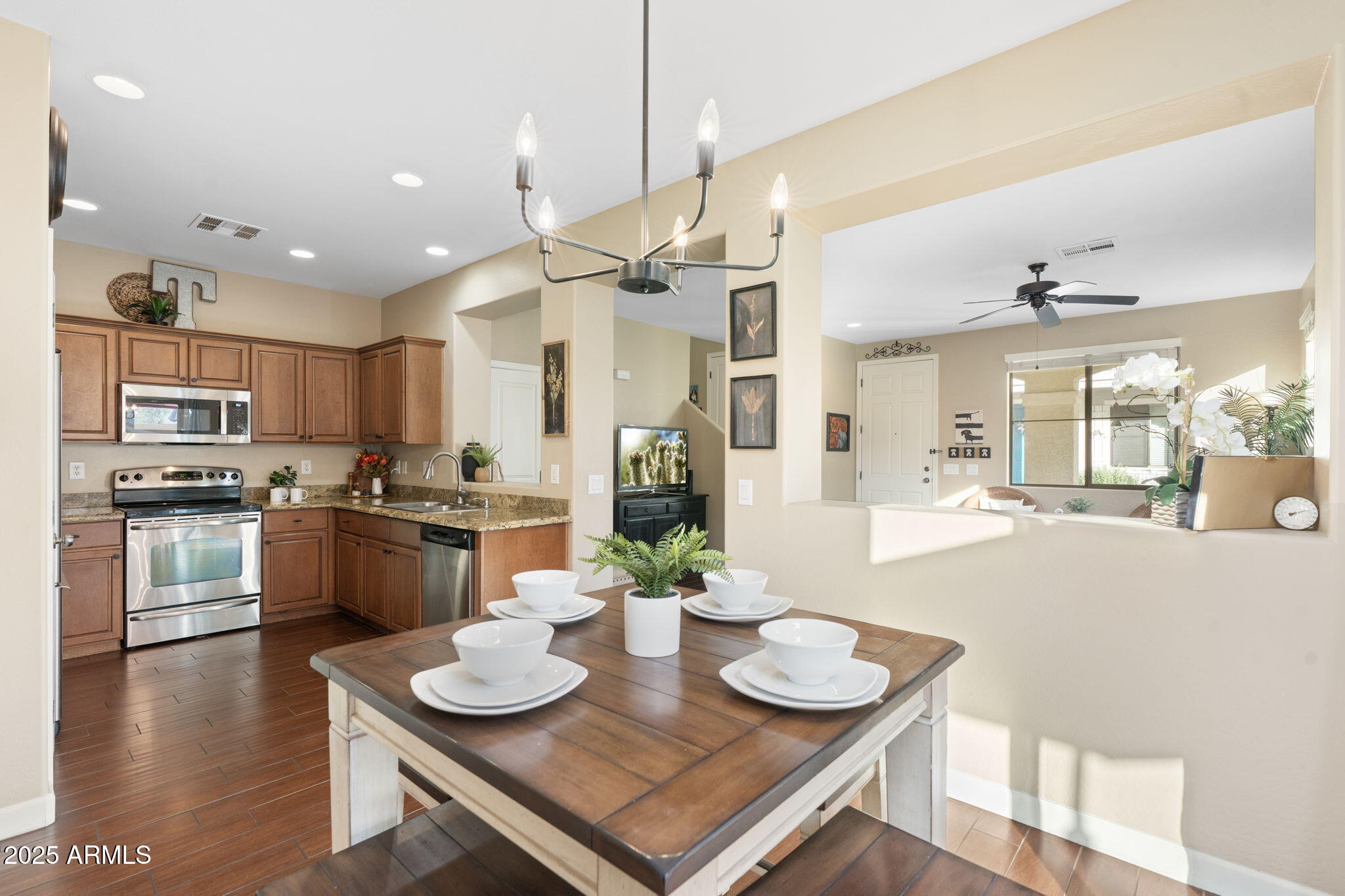 1705 East Joseph Way Gilbert, AZ 85295 - Photo 8 of 39 a kitchen with stainless steel appliances kitchen island granite countertop a stove a sink a dining table and chairs
