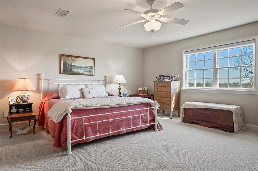 14410 Fm 455 Street West Decatur, TX 76234 - Photo 26 of 40 a spacious bedroom with a bed and a chandelier