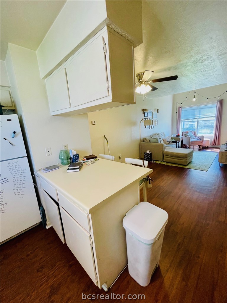 922 Spring Loop, Unit A College Station, TX 77840 - Photo 20 of 20 Kitchen featuring a ceiling fan, dark wood finished floors, white cabinets, a textured ceiling, and open floor plan