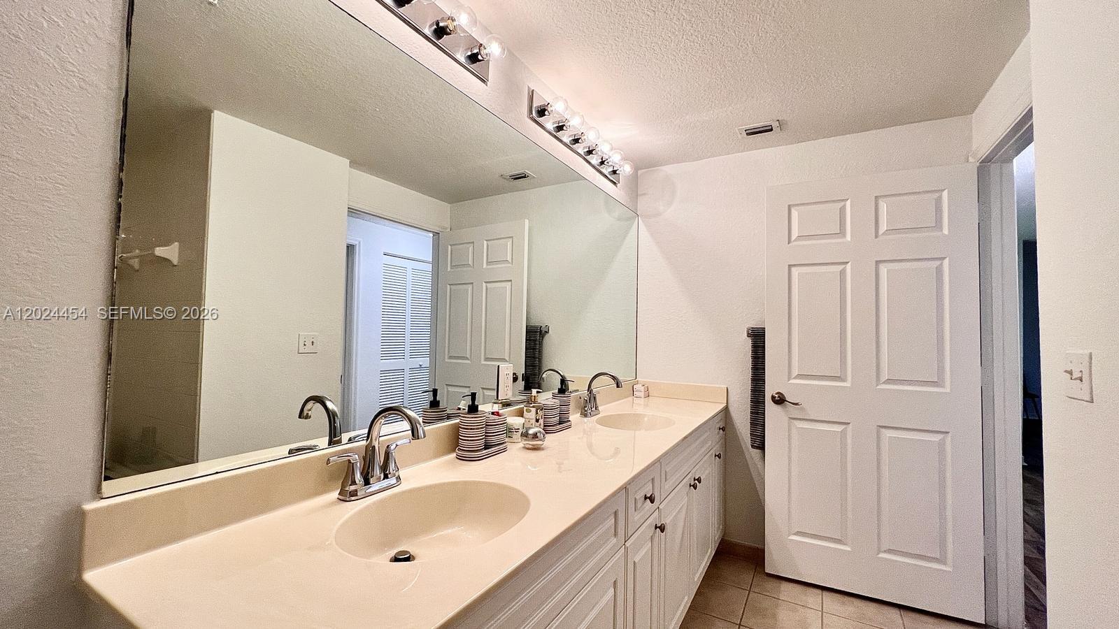 2727 Anzio Court, Unit 106 Palm Beach Gardens, FL 33410 - Photo 23 of 43 a bathroom with double vanity sink and a mirror