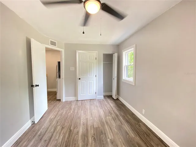a view of hallway with a ceiling fan and wooden floor