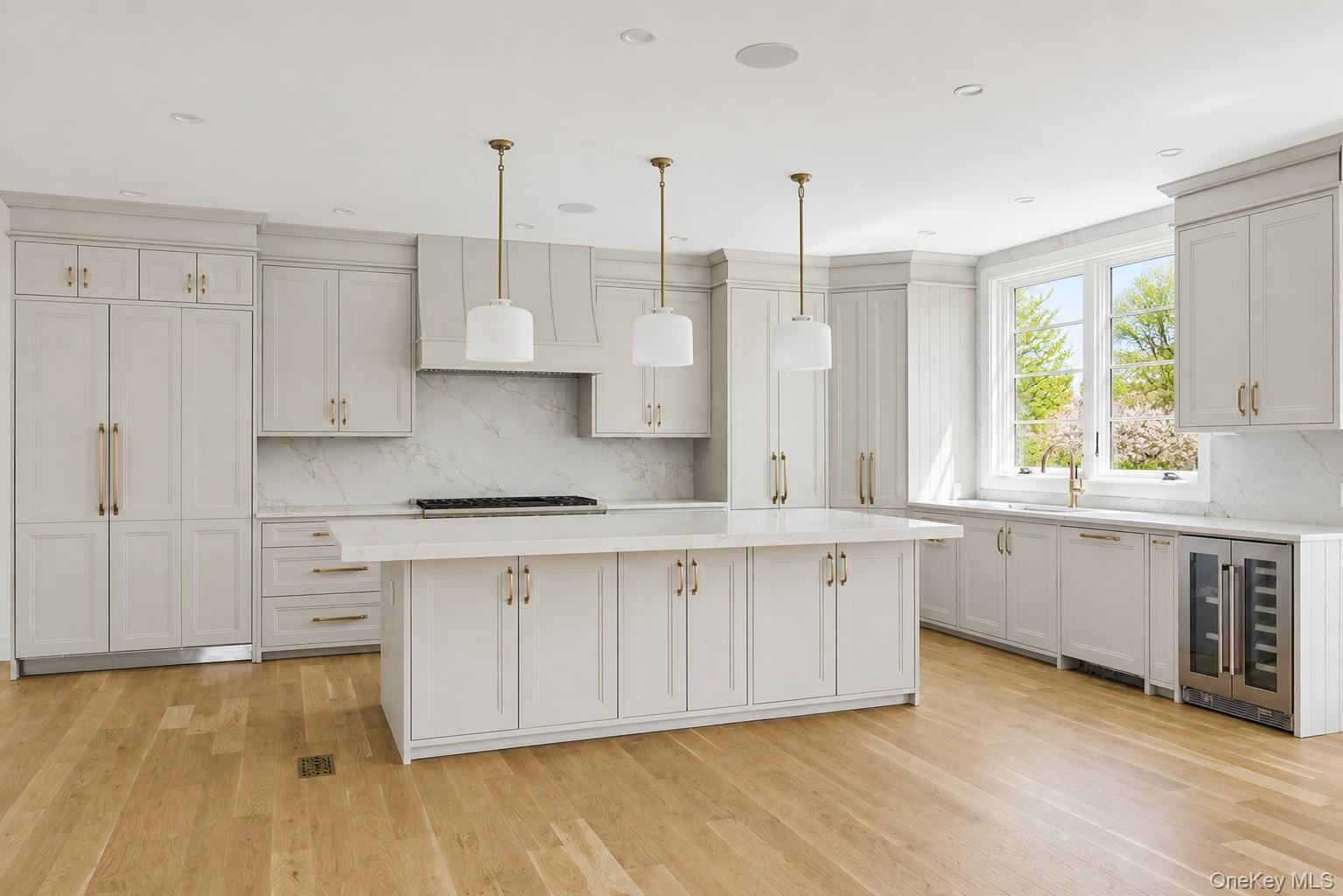 14 Ridge Road Southampton, NY 11968 - Photo 3 of 23 a kitchen with stainless steel appliances granite countertop a stove a sink and white cabinets with wooden floor