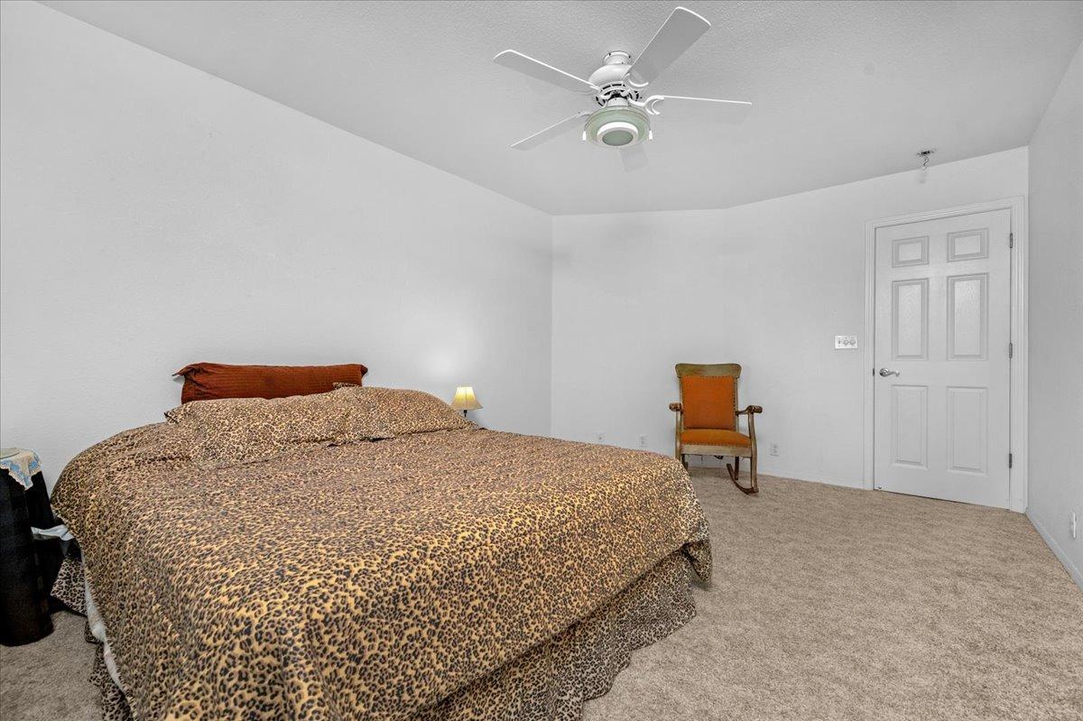 10925 Rusty Spur Lane Clovis, CA 93619 - Photo 29 of 94 a bedroom with a bed and a chandelier