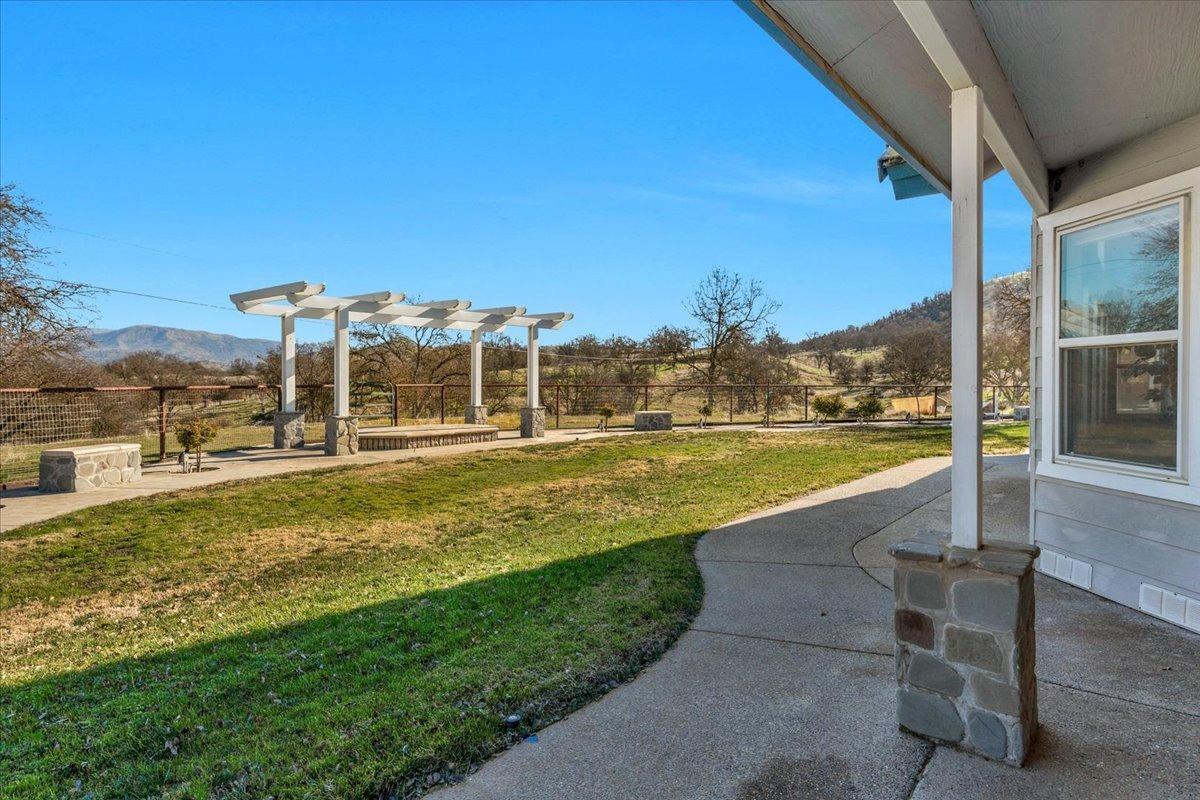 10925 Rusty Spur Lane Clovis, CA 93619 - Photo 52 of 94 a view of a swimming pool with a lawn chairs under an umbrella