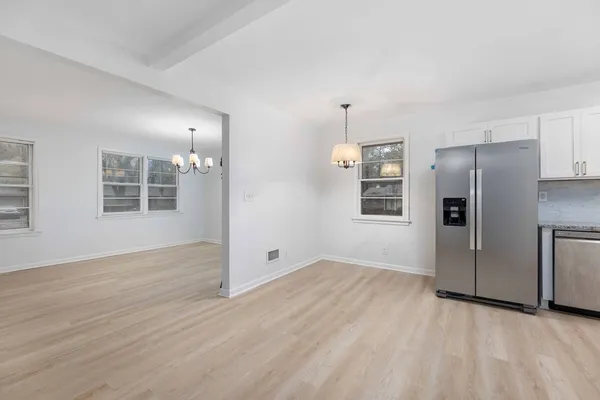 a view of an empty room with window and wooden floor