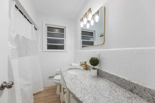 a bathroom with a granite countertop sink and a mirror