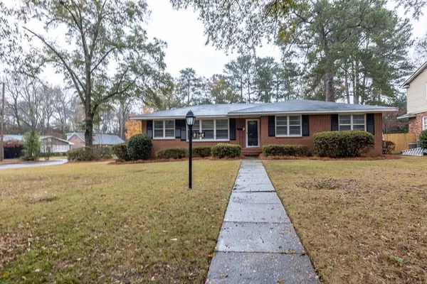 a front view of a house with a yard and trees