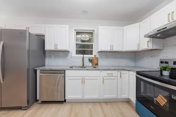 a kitchen with stainless steel appliances granite countertop a sink stove and refrigerator