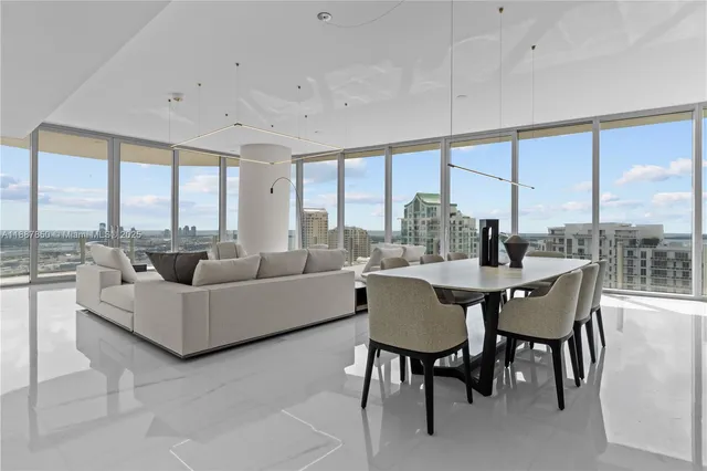 a dining room with furniture and a floor to ceiling window