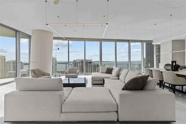 a hotel room with two couches and a flat screen tv