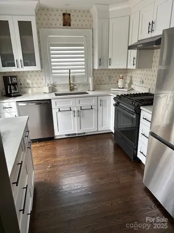 a kitchen with stainless steel appliances granite countertop a stove a sink and a microwave