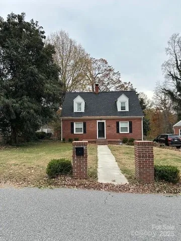 a front view of a house with a yard covered with snow