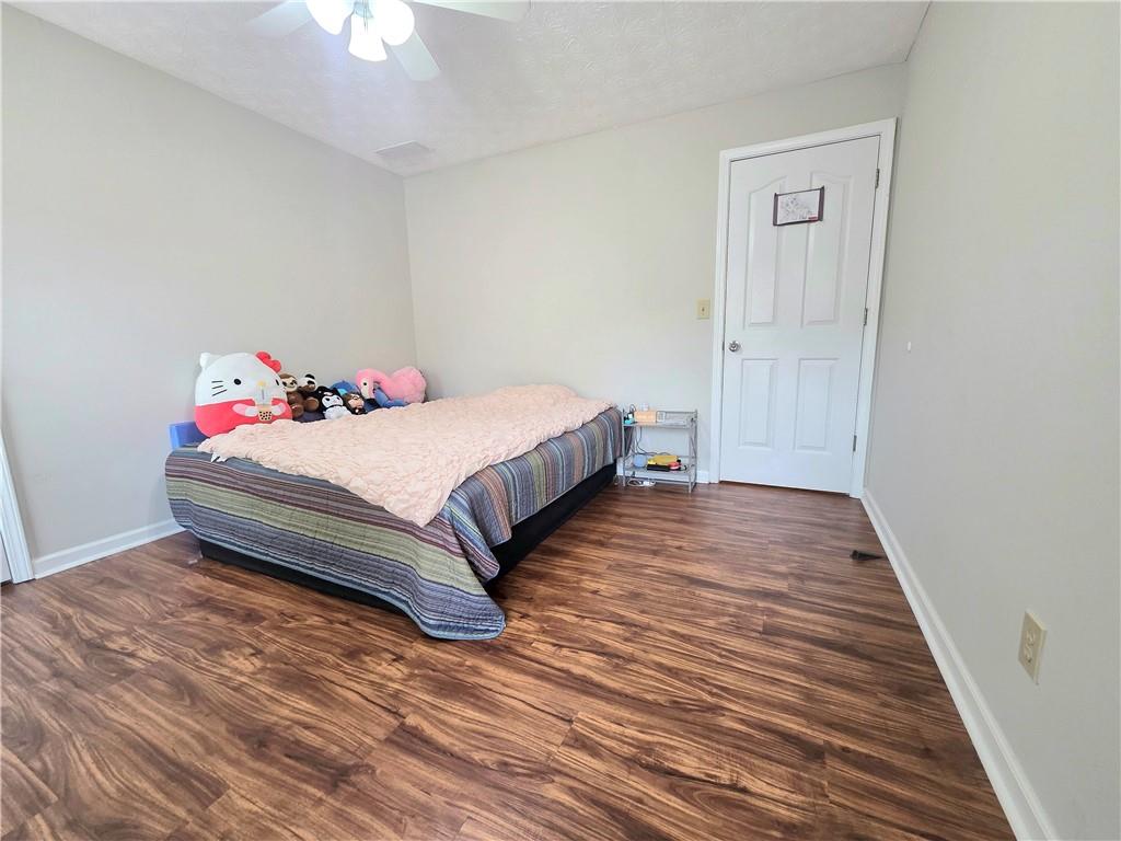 2395 Ashton Ridge Drive Dacula, GA 30019 - Photo 22 of 38 a bedroom with a bed and a chandelier