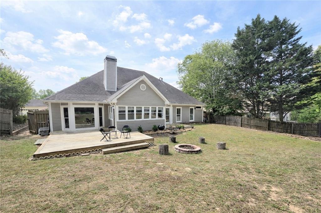 2395 Ashton Ridge Drive Dacula, GA 30019 - Photo 33 of 38 a view of a house with large trees and wooden fence