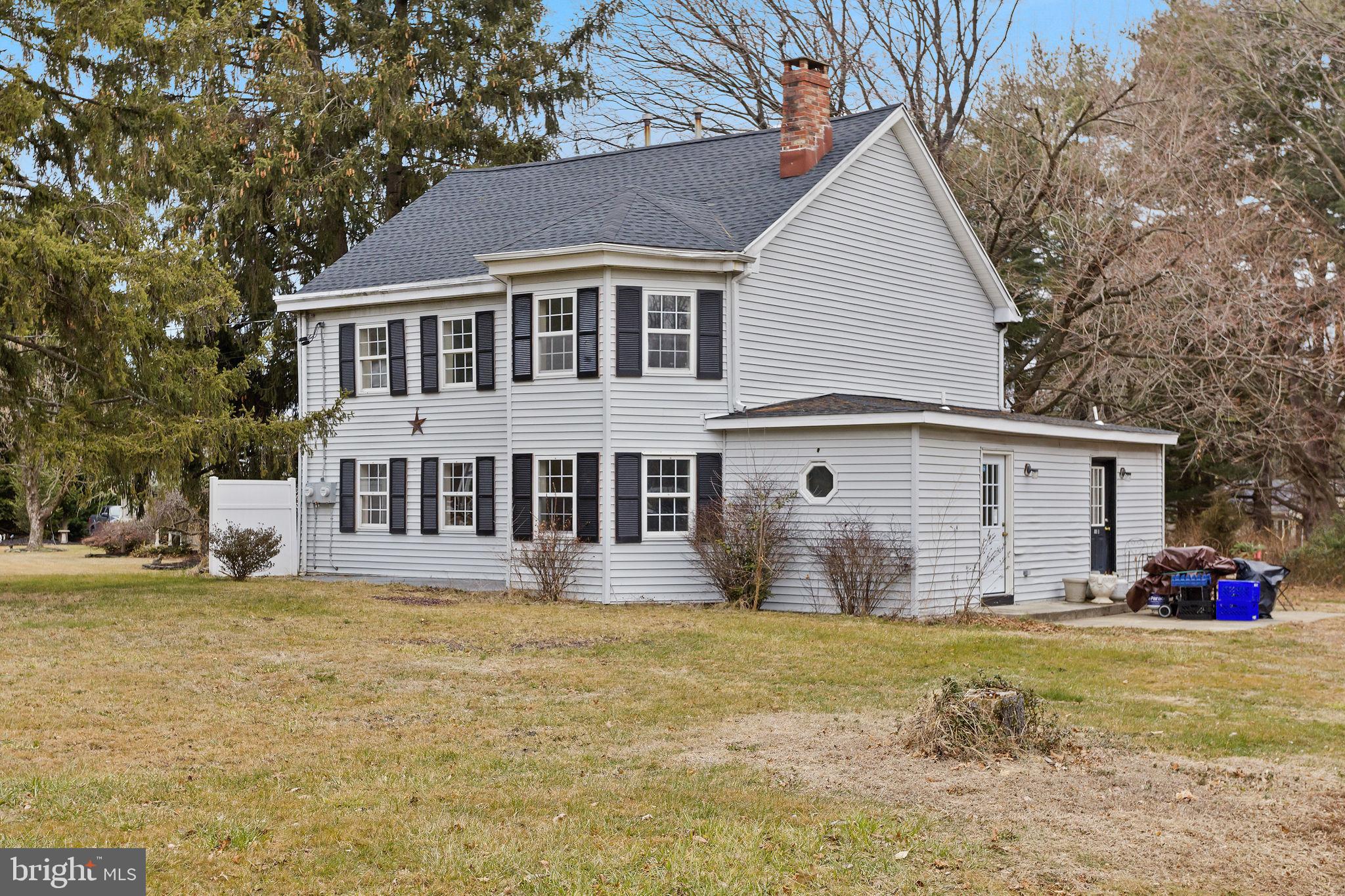 a front view of house with yard and trees around