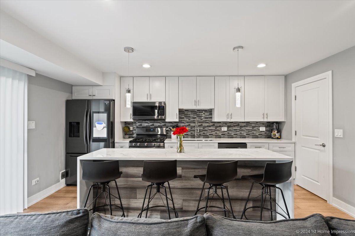 7 Cour Versaille Palos Hills, IL 60465 - Photo 7 of 20 a kitchen with stainless steel appliances a dining table chairs refrigerator and cabinets