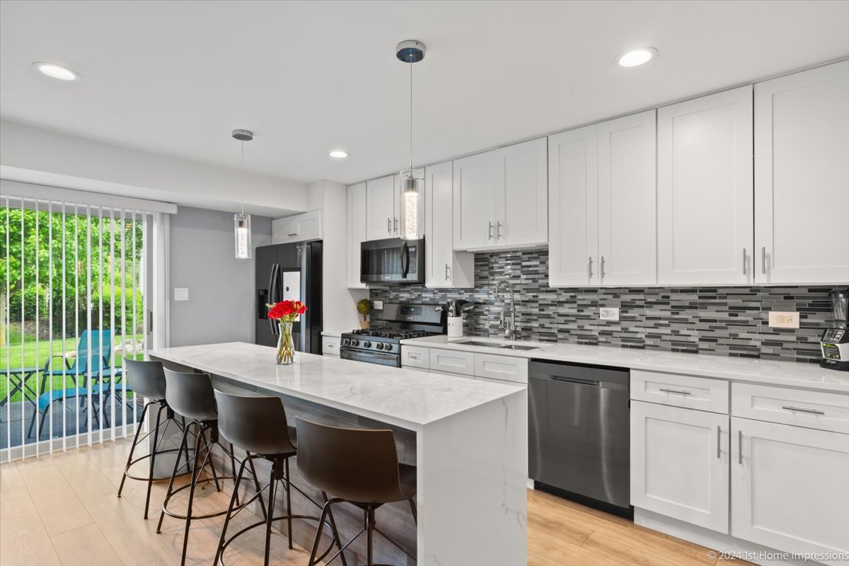 7 Cour Versaille Palos Hills, IL 60465 - Photo 8 of 20 a kitchen with stainless steel appliances granite countertop a stove top oven a sink dishwasher and a refrigerator with wooden floor