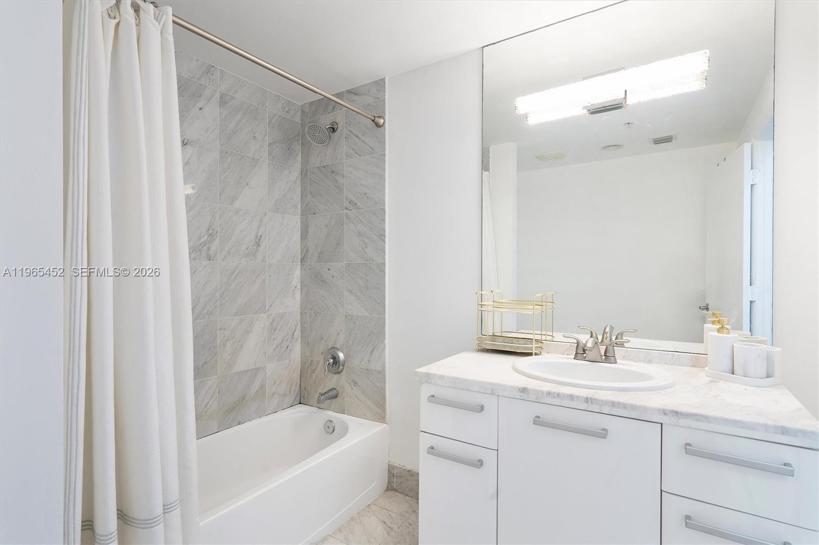 253 Northeast 2nd Street, Unit 223 Miami, FL 33132 - Photo 11 of 16 a bathroom with a bath tub sink mirror and a shower