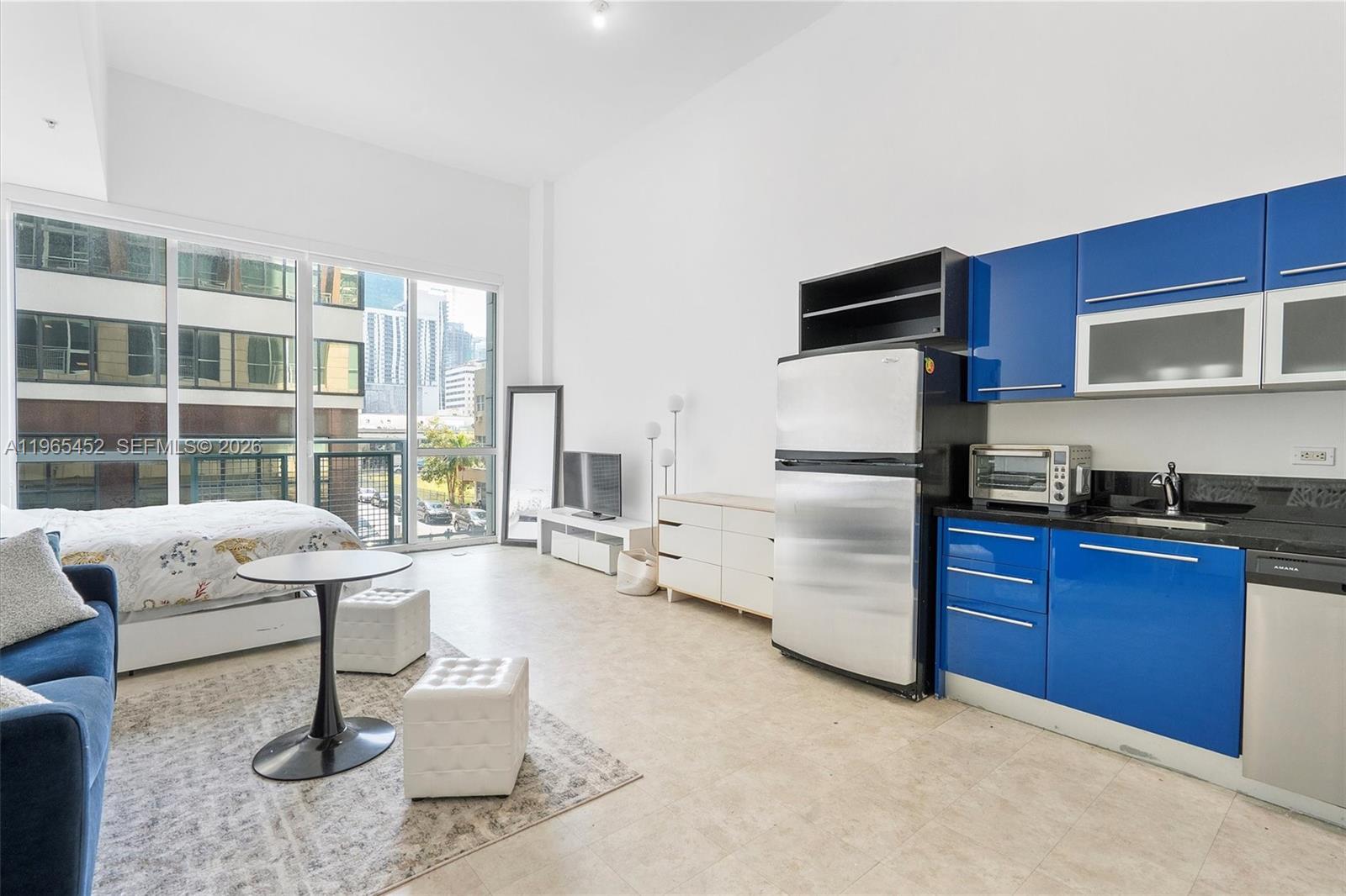 253 Northeast 2nd Street, Unit 223 Miami, FL 33132 - Photo 2 of 16 a living room with stainless steel appliances furniture a flat screen tv and a window