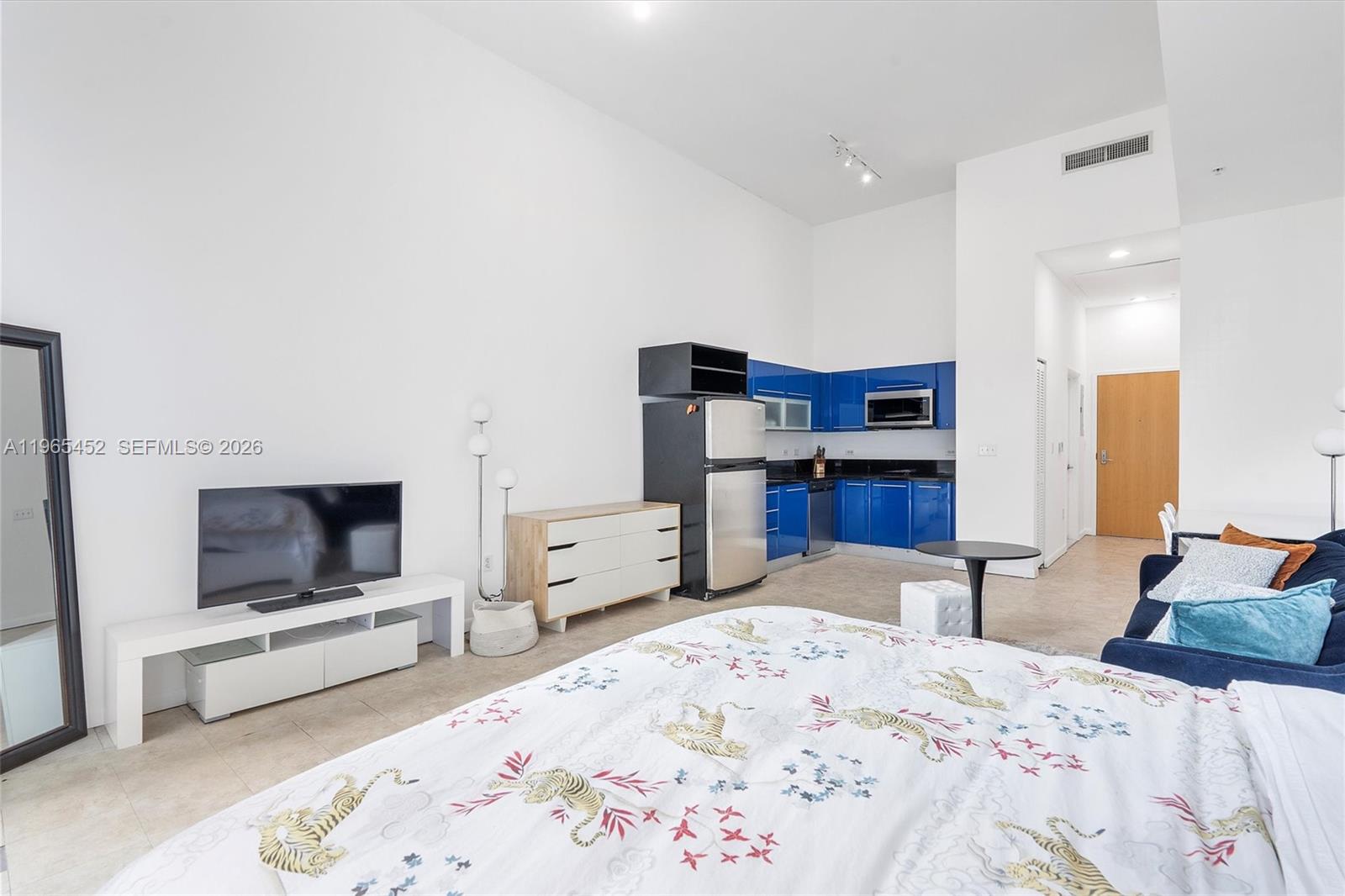 253 Northeast 2nd Street, Unit 223 Miami, FL 33132 - Photo 3 of 16 a bedroom with furniture and a flat screen tv