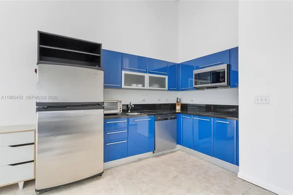 a kitchen with stainless steel appliances granite countertop a refrigerator stove and microwave