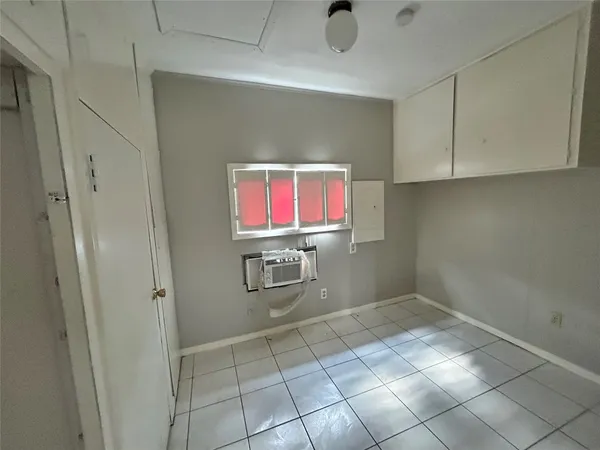 a room with washing machine and cabinets